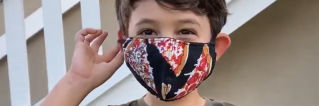 Boy putting on a face mask.