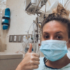 Contributor in hospital wearing a mask and giving thumbs up