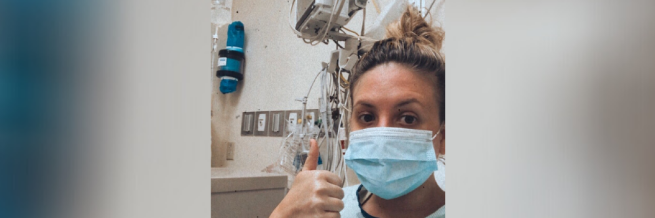 Finding a Doctor Who Actually Helped Treat My Chronic Pain Contributor in hospital wearing a mask and giving thumbs up