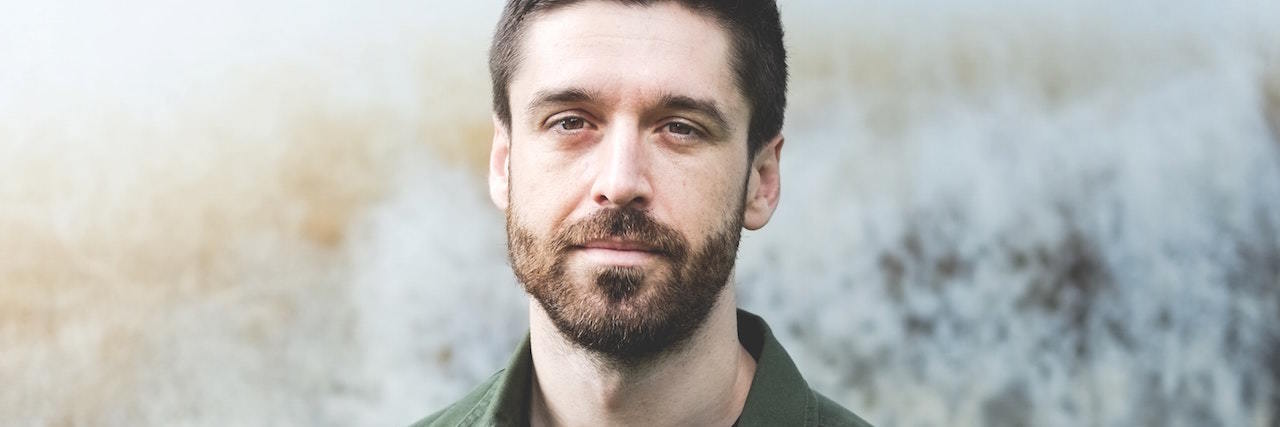 Mental Illness Is Not a 'Trendy' Fashion Statement A man who looks serious, wearing a green jacket