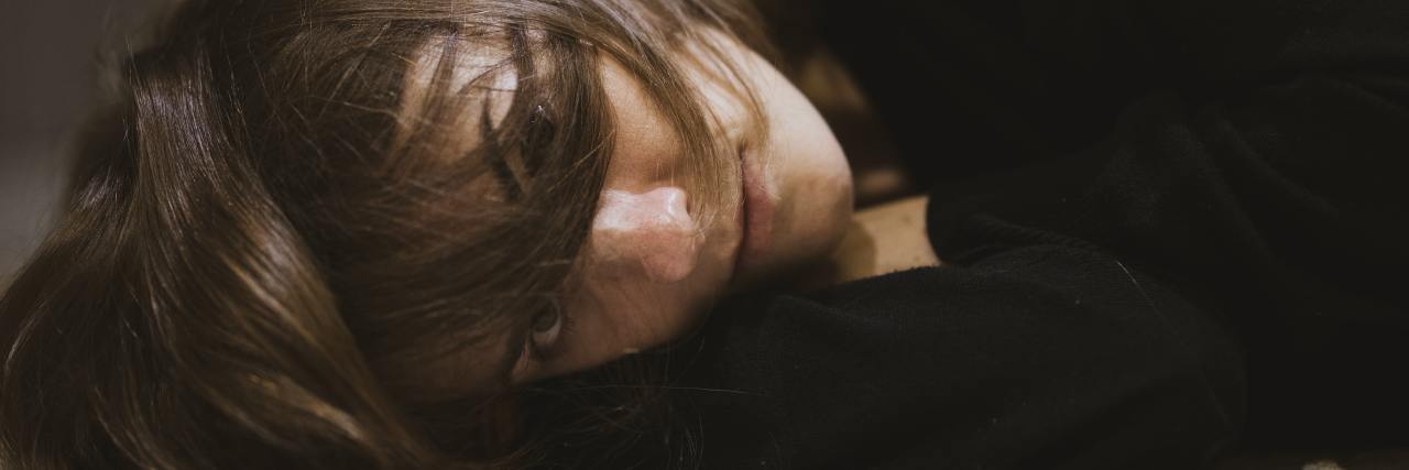 Why I Had Body Dysmorphic Disorder Since Childhood photo of woman lying on floor looking into camera