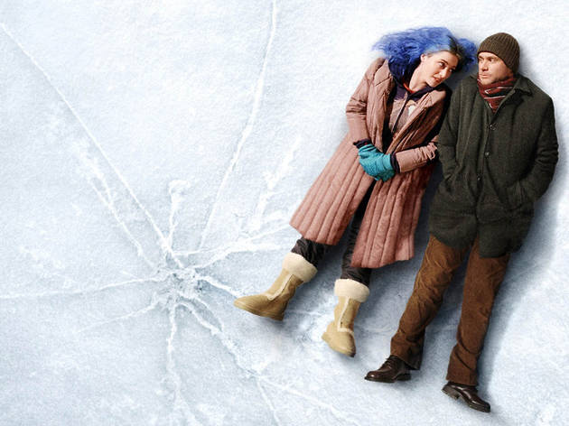 A couple lies down on a sheet of ice, leaning against each other