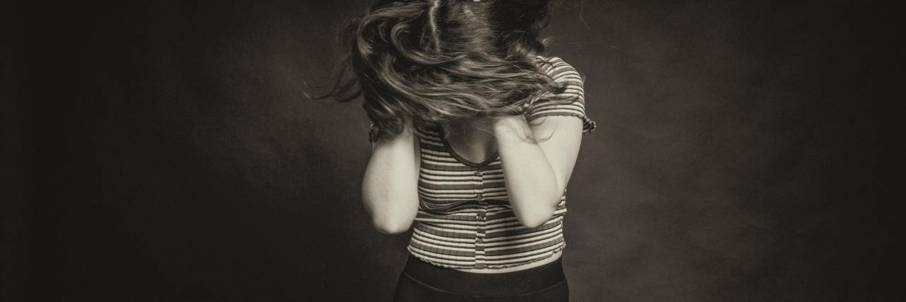 monotone photo of woman with hands on head messing up her hair