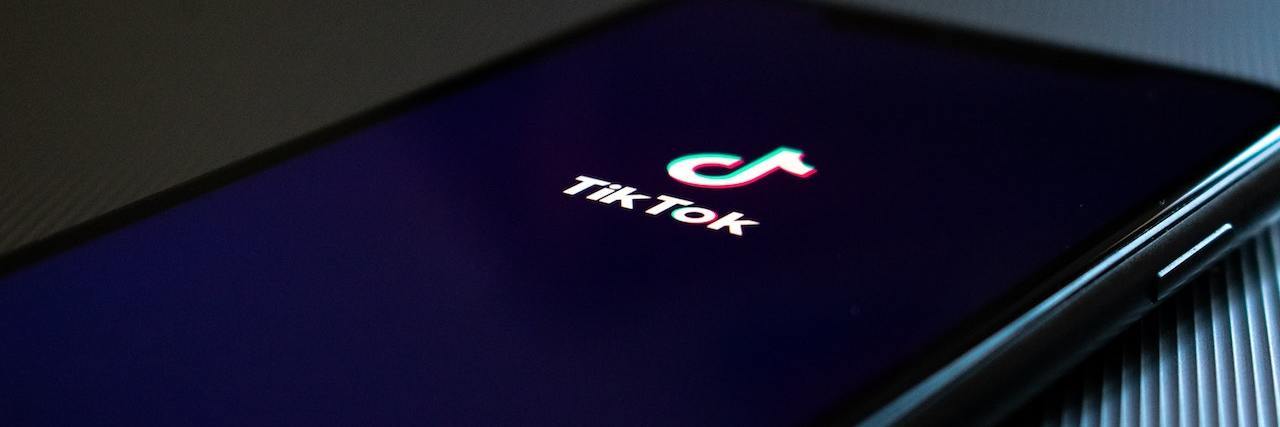 Phone on a table showing a black screen with the TikTok logo