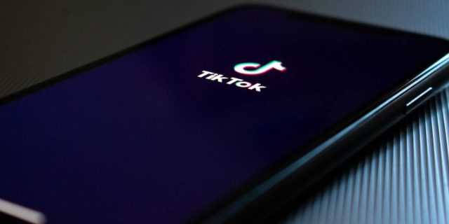 Phone on a table showing a black screen with the TikTok logo