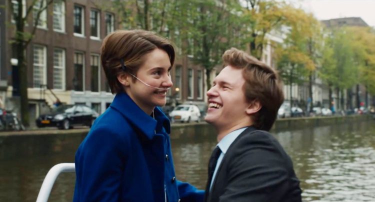 The two lead characters in the Fault in Our Stars laugh outside near a river