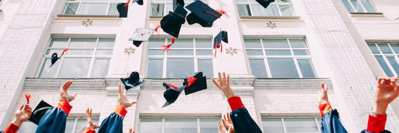 graduates throwing up their caps in the air