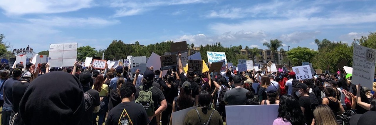 How to Safely Protest During the COVID-19 Pandemic Group of Black Lives Matter protesters gathered under a blue sky
