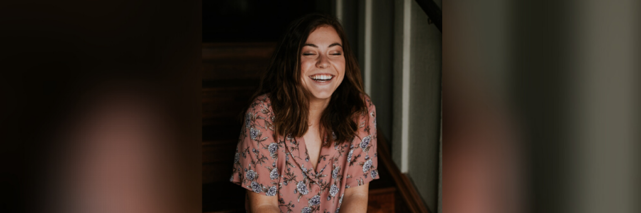Young woman sitting on stairs and smiling