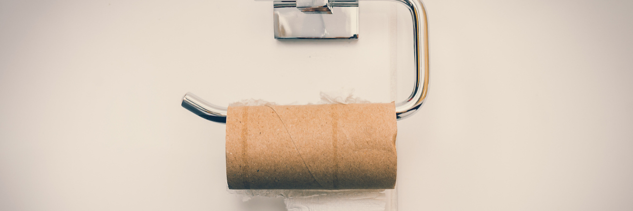 Living With Pica: Why I Ate Toilet Paper Every Day for 15 Years Empty toilet paper roll in public restroom