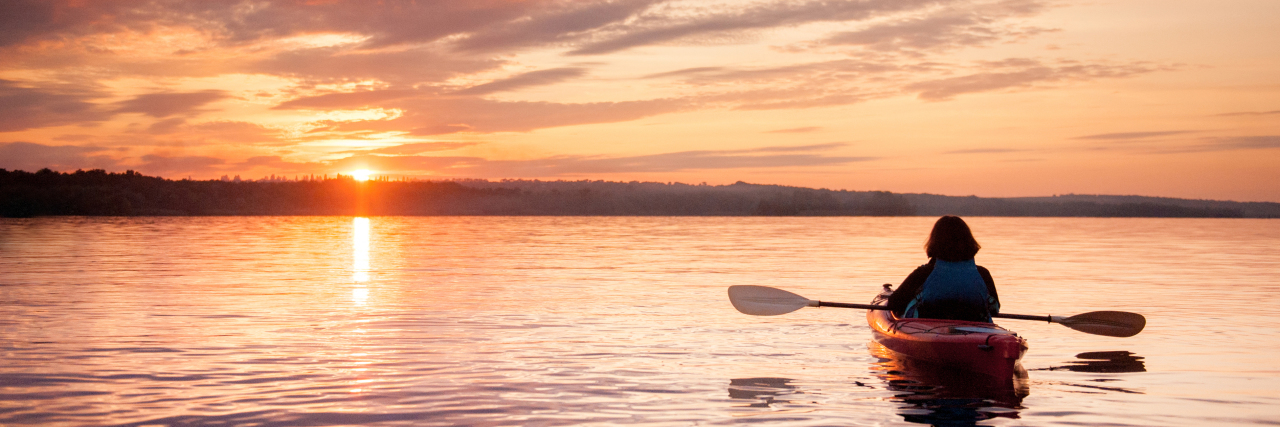 Living With Mal de Debarquement Syndrome Woman in a kayak on the river