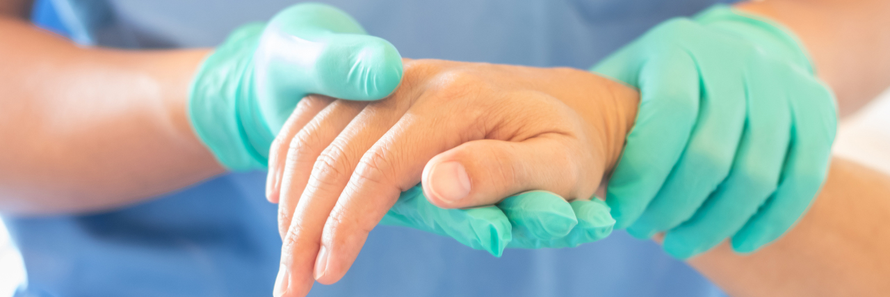 How COVID-19 Is Limiting Health Care Access for Disabled People Doctor holding patient's hand.