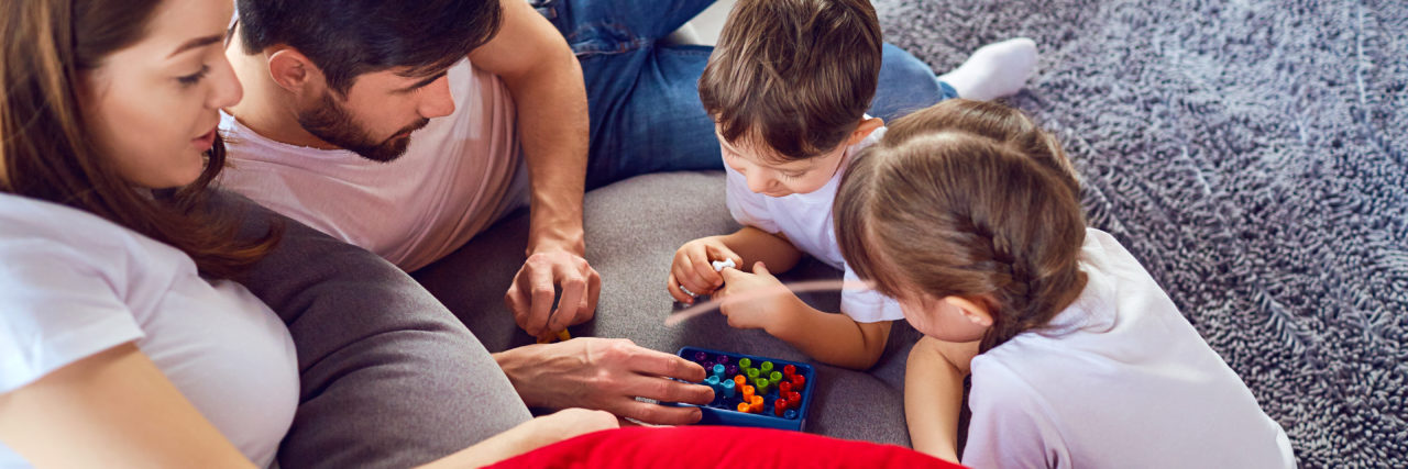 Parenting With Chronic Illness During COVID-19 Family playing board game
