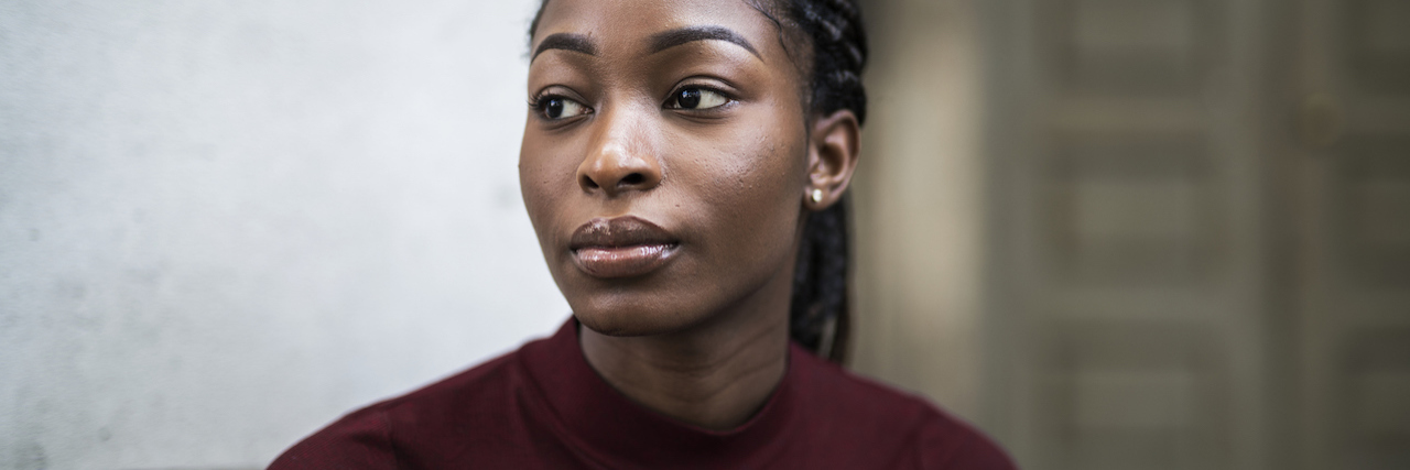We Need Take Care of Black Mental Health After Police Shootings A black woman with braids looking serious