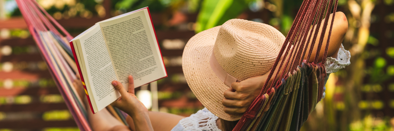 Being an Introvert on the Autism Spectrum Woman in a hammock reading a book.
