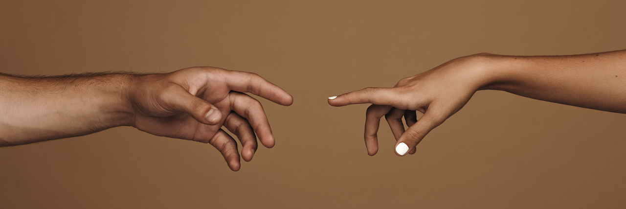 13 Ways to Stay Connected With Loved Ones When You Can't Touch Close up of man and woman hand about to touch with index finger.