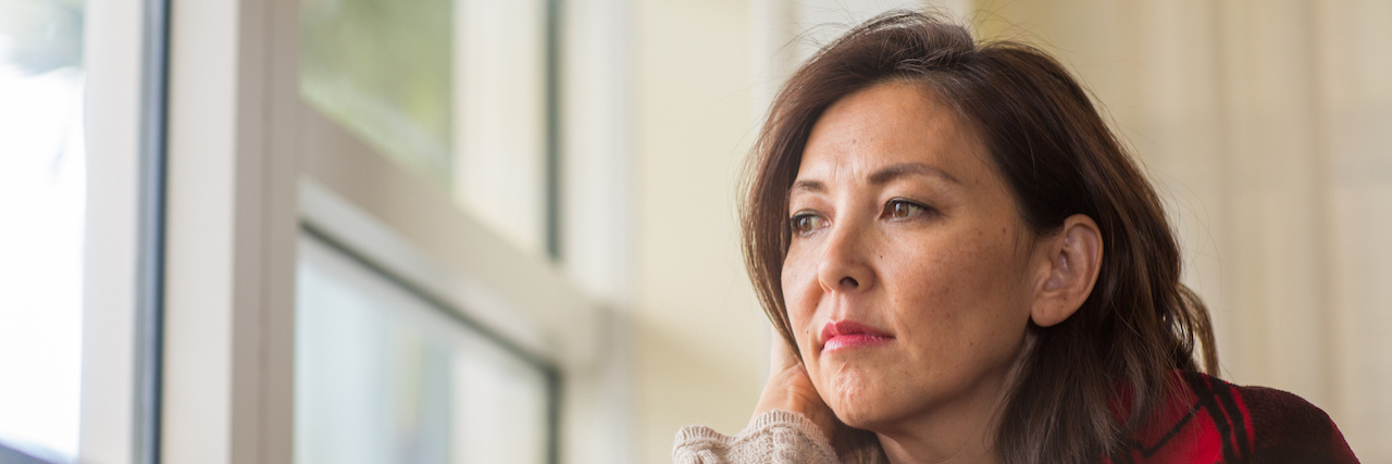 New Study Highlights How Depression and Heart Health May Be Linked Sad woman looking out the woman.