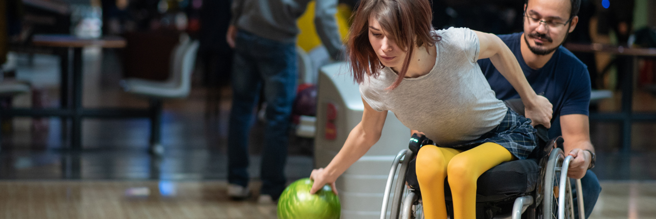 Young disabled woman in a wheelchair bowling.