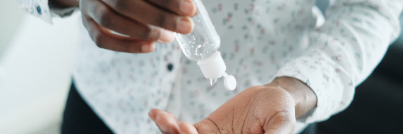 FDA Warns Against Hand Sanitizers With Harmful Ingredient Back woman using liquid hand sanitizer.