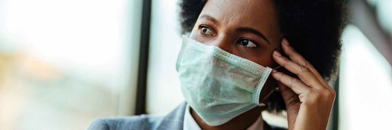 Tips for Dealing With Fear of the Unknown During COVID-19 woman wearing a face mask, looking stressed