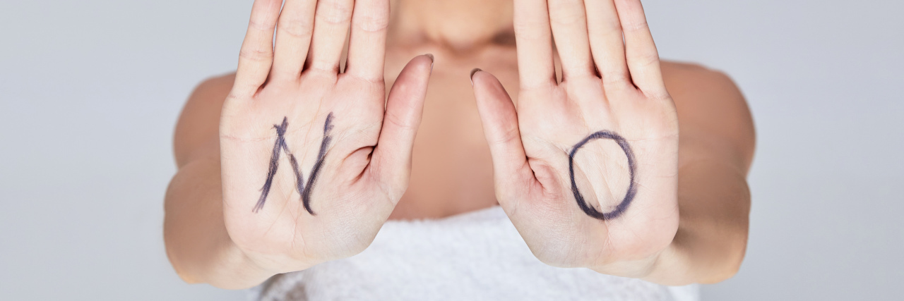 Learning to Say 'No' in My Life With Chronic Illness Woman with the letters "NO" written on her hands.