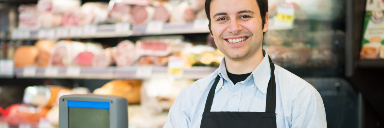 Working Customer Service as a Man With Autism Clerk in grocery store.