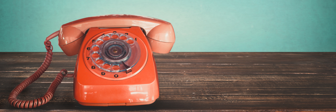 Why Answering Phone Calls Can Be Hard With a Chronic Illness Red vintage telephone on table.