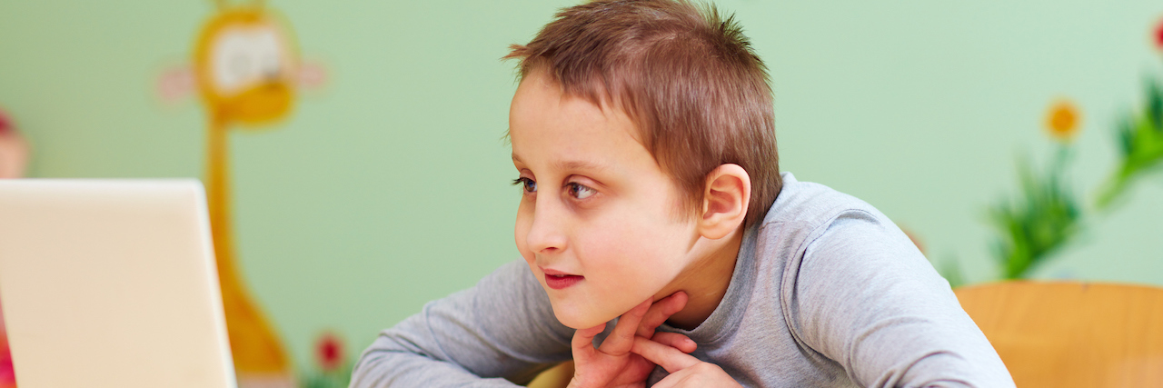 Dept. of Education Issues New COVID-19 Guidance for Disabled Students Young white boy looking intently at an open laptop screen