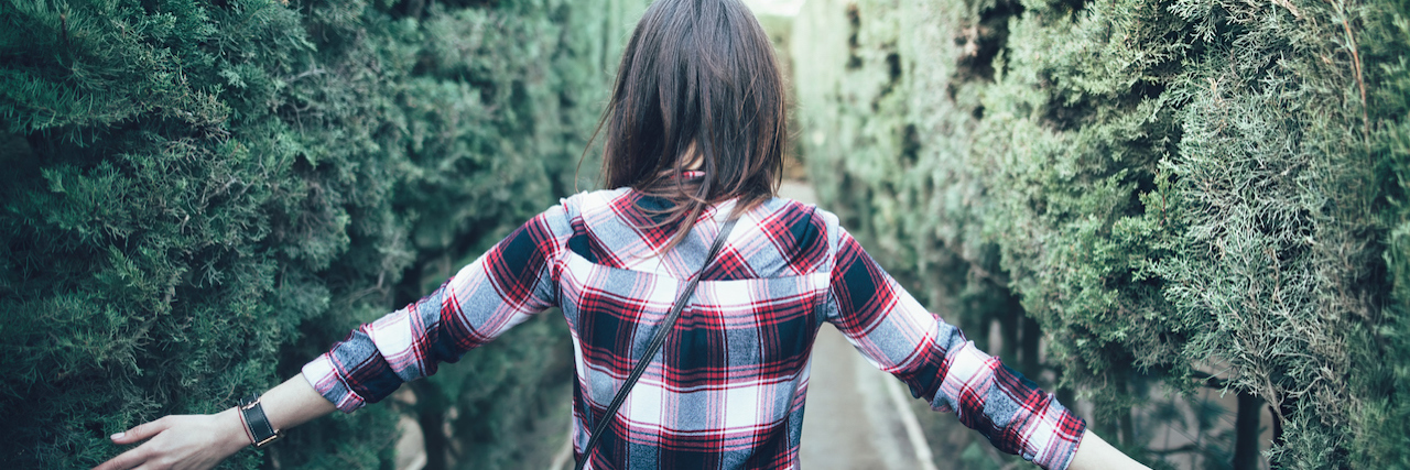 Explaining PTSD to Those Trying to Understand Woman walking through maze of hedges