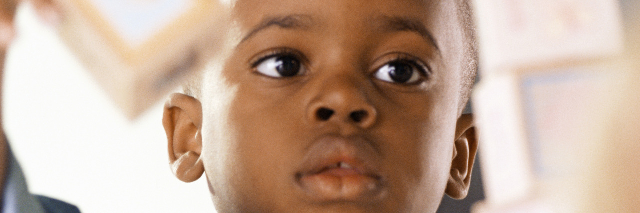 How Systemic Racism Harms Children With Autism Black boy playing with building blocks.