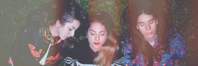 Haim sisters lying on their front lawn in Los Angeles