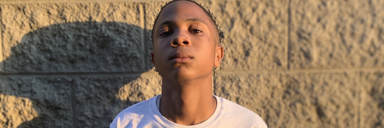 Black Lives Matter Poem By a Black, Nonspeaking Teenager With Autism Justice, a young black man, against a wall