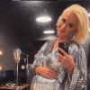 Katy Perry takes a mirror selfie while wearing a sparkly silver outfit