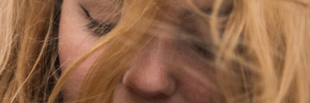 How I Made Myself Feel Less Alone After a Flashback A woman with windswept hair in her face