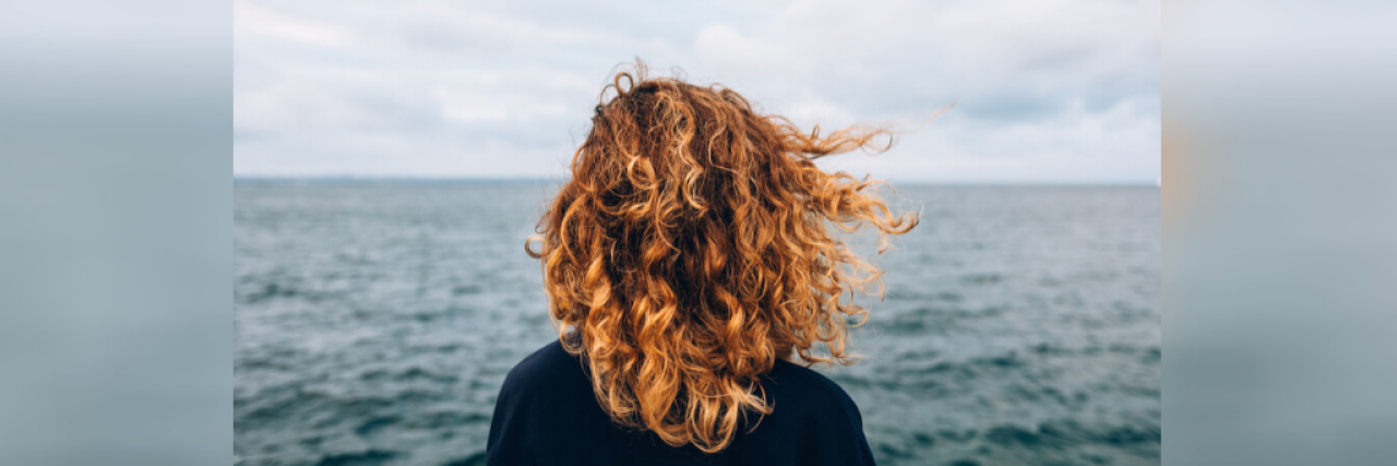 Grappling With the Experience of Losing Loved Ones in Different Ways Woman looking out over the ocean facing away from the camera