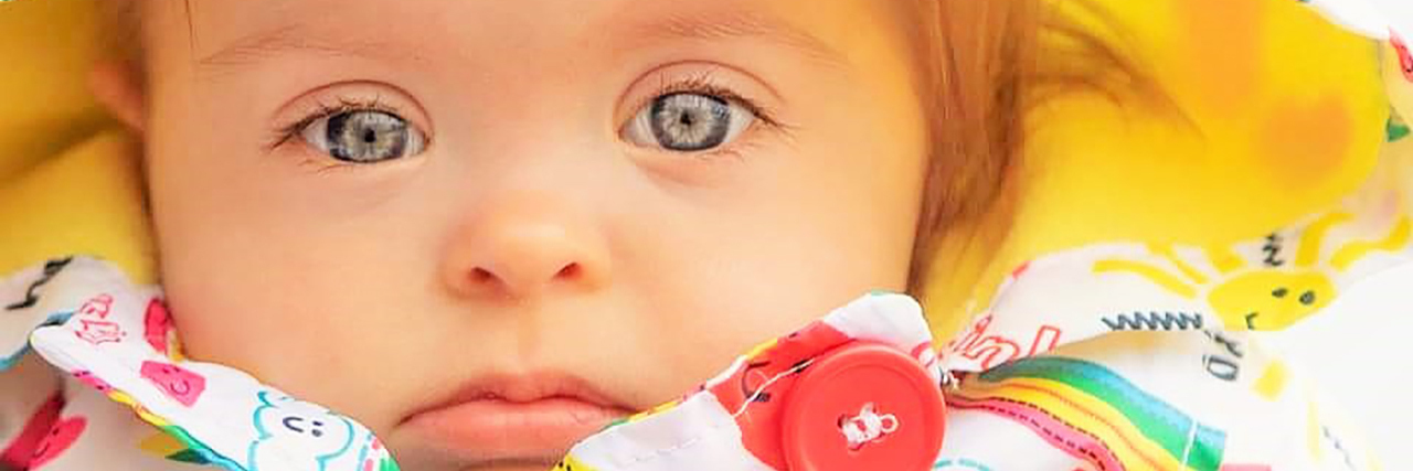 The Value of Friendship for My Daughter With Down Syndrome Betsy surrounded by a rainbow blanket.
