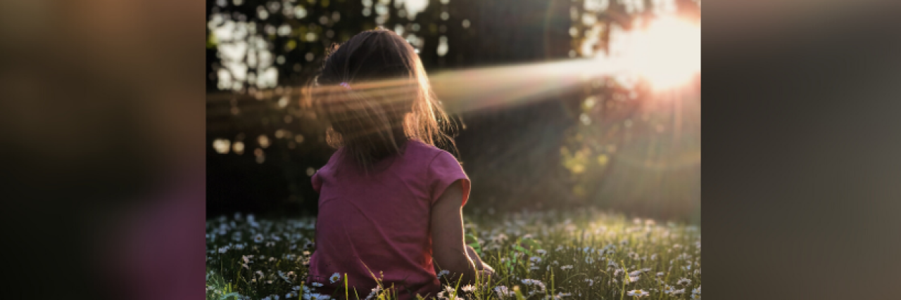 It's OK to Be Angry and Sad About Losing Your Childhood to Cancer Young girl sitting in wildflower field by the woods