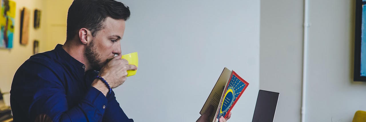 How Strict Routines Help (and Hurt) People With Anxiety a man at his desk reading a book and sipping coffee