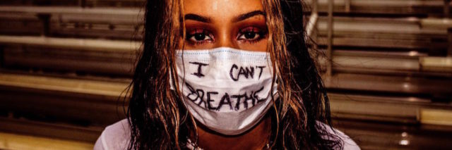 A woman with a mask that says "I can't breathe"