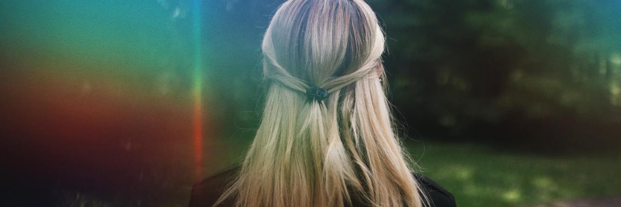 Childhood Emotional Abuse Explains Why I Froze During Sexual Assault photo of blonde woman from behind with rainbow light flare