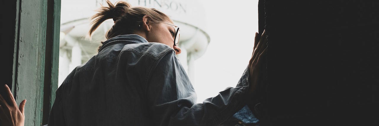 Why Sirens Are One of My PTSD Triggers a woman looking out the window