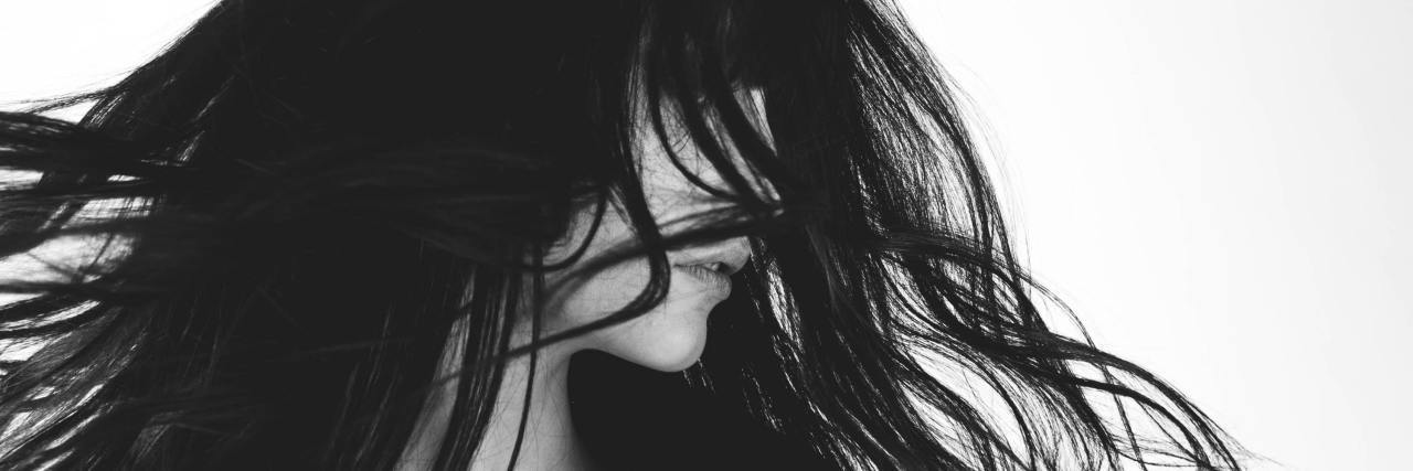 When You’re Not Glad to Be Alive After a Suicide Attempt black and white photo of woman looking away with hair flying around her