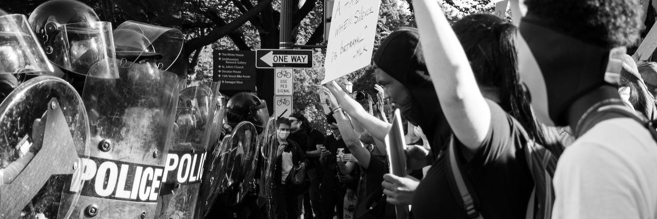 Police Using Rubber Bullets on Protesters That Can Kill, Blind or Maim Black and white photo of police with shields facing a line of Black Lives Matter protesters