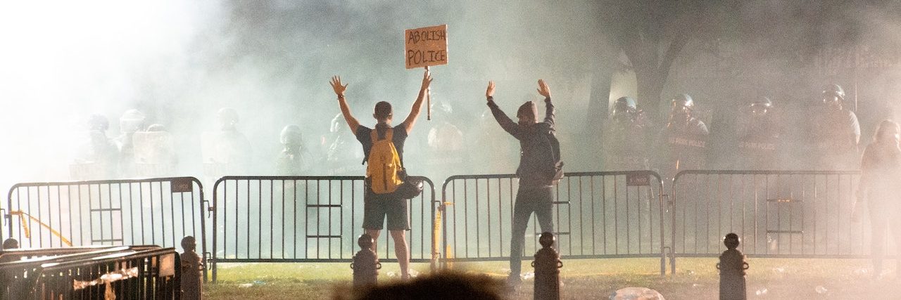 Police Use of Tear Gas at Protests Likely Increases COVID-19 Risks Long shot of protestors amid clouds of tears gas at a Black Lives Matter protest in Washington, D.C.