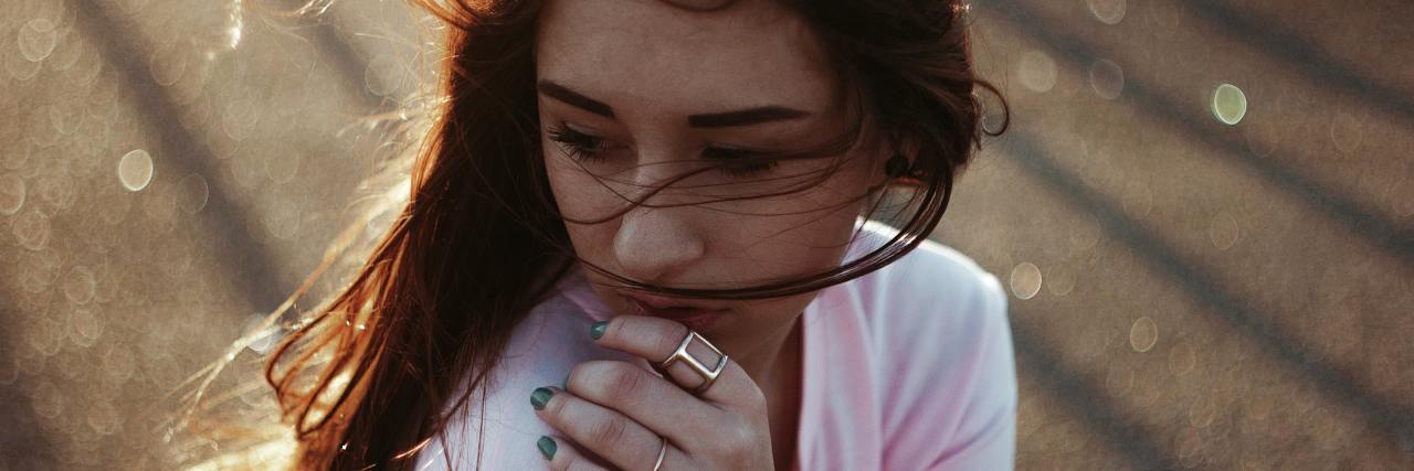 Bipolar Disorder and Bullying Makes Me Afraid of Offending People photo of woman with blurry field behind her, looking anxious