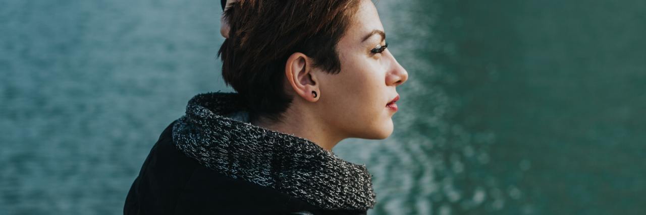 I Told My Mother I’m Done With The Emotional Abuse of ‘Covert Incest’ photo of woman with short hair standing by water and looking off into distance
