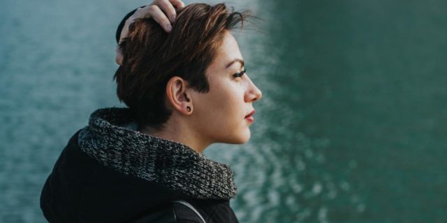 I Told My Mother I’m Done With The Emotional Abuse of ‘Covert Incest’ photo of woman with short hair standing by water and looking off into distance