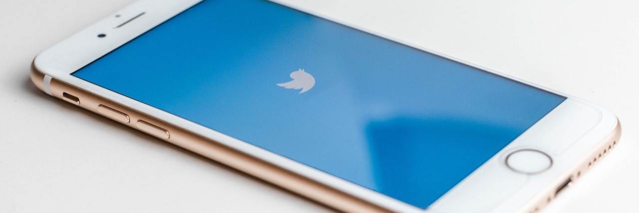 Iphone on a table with the blue Twitter launch screen