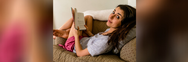 Contributor reading a book on her couch