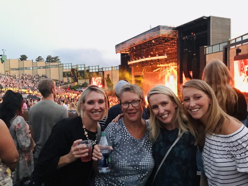 photo of contributor and three other women at a concert, smiling